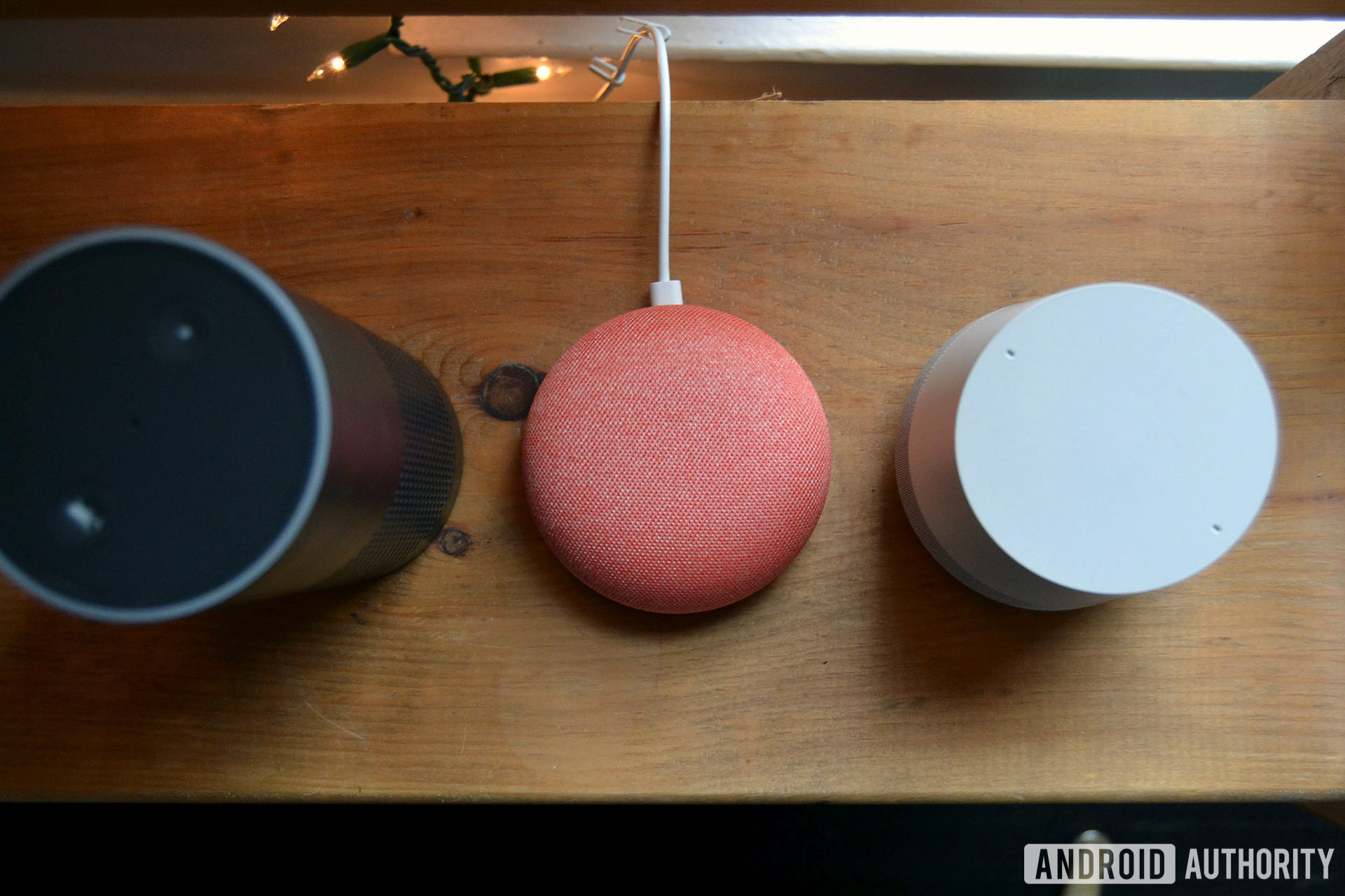 Amazon Echo，Google Home Mini和Google Home自上而下的图像在木桌上。