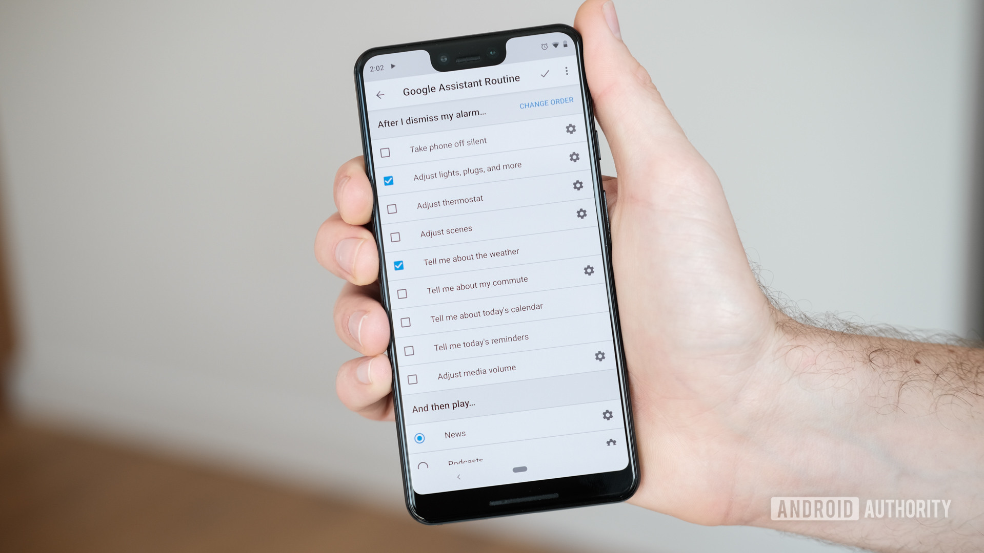 手持手机的手拿着Google Assistant例行菜单。
