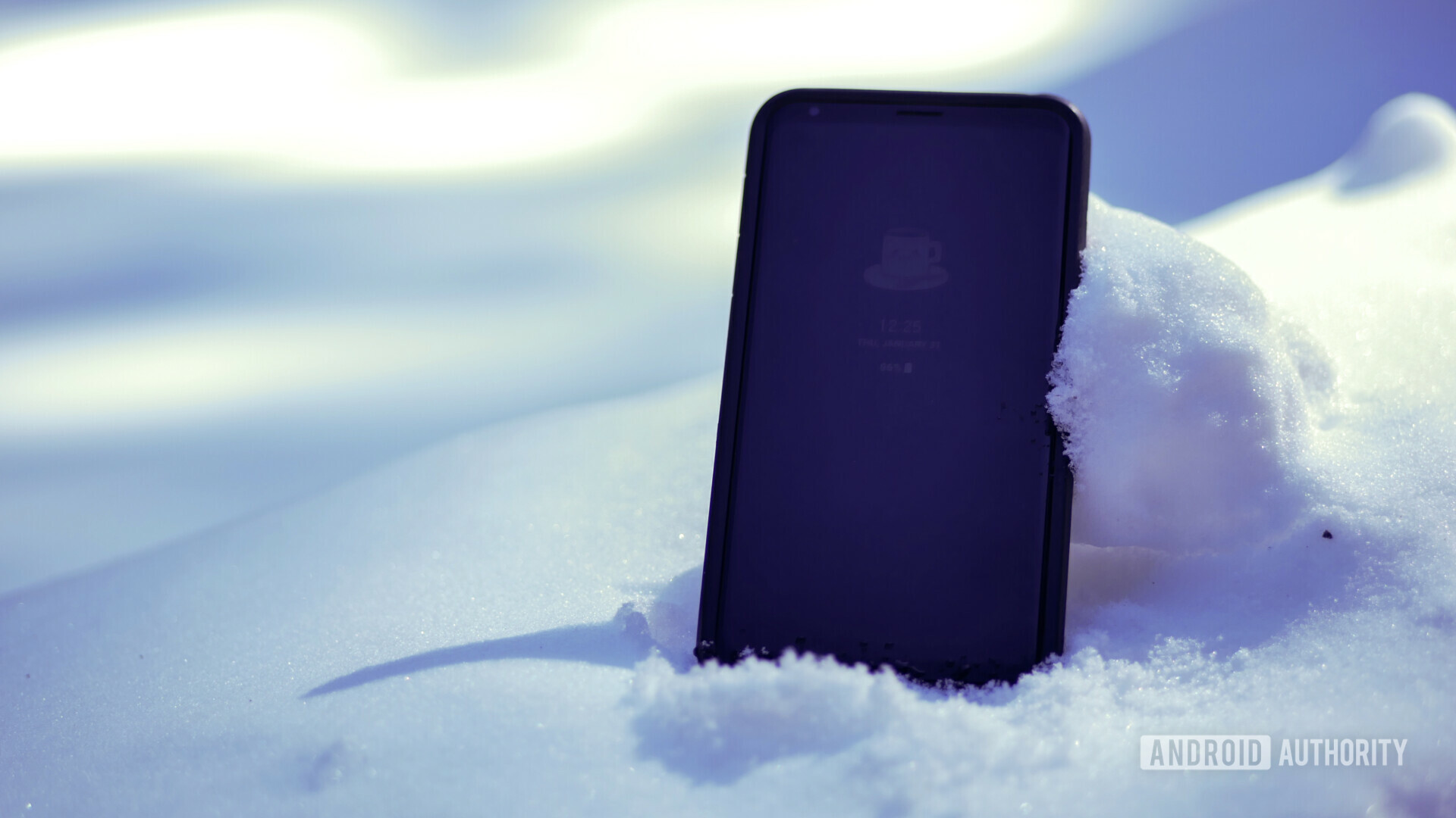 一部冷手机在一些白雪中半烧了。