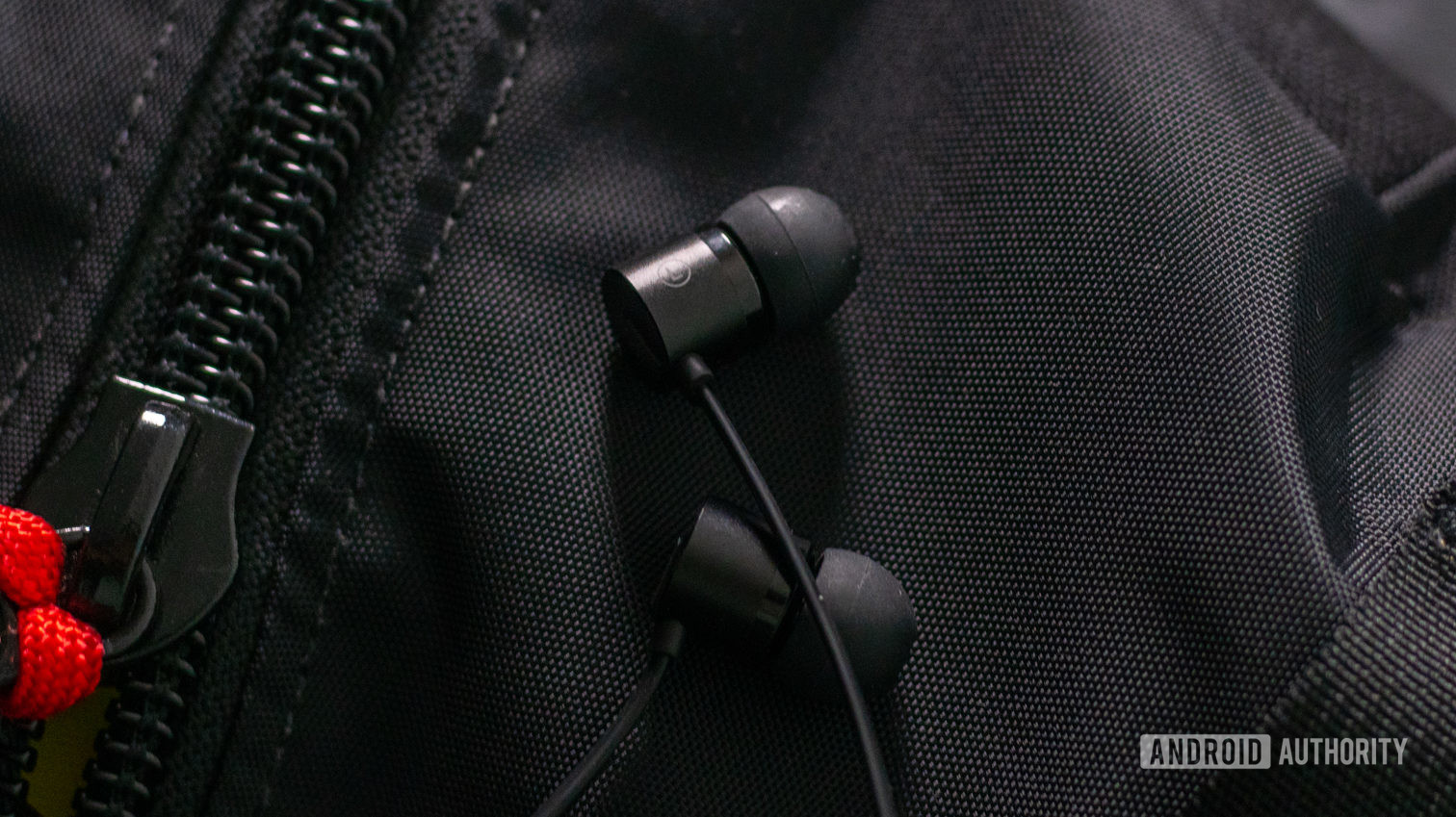 OnePlus子弹USB-C耳机在黑色背包上耳塞。