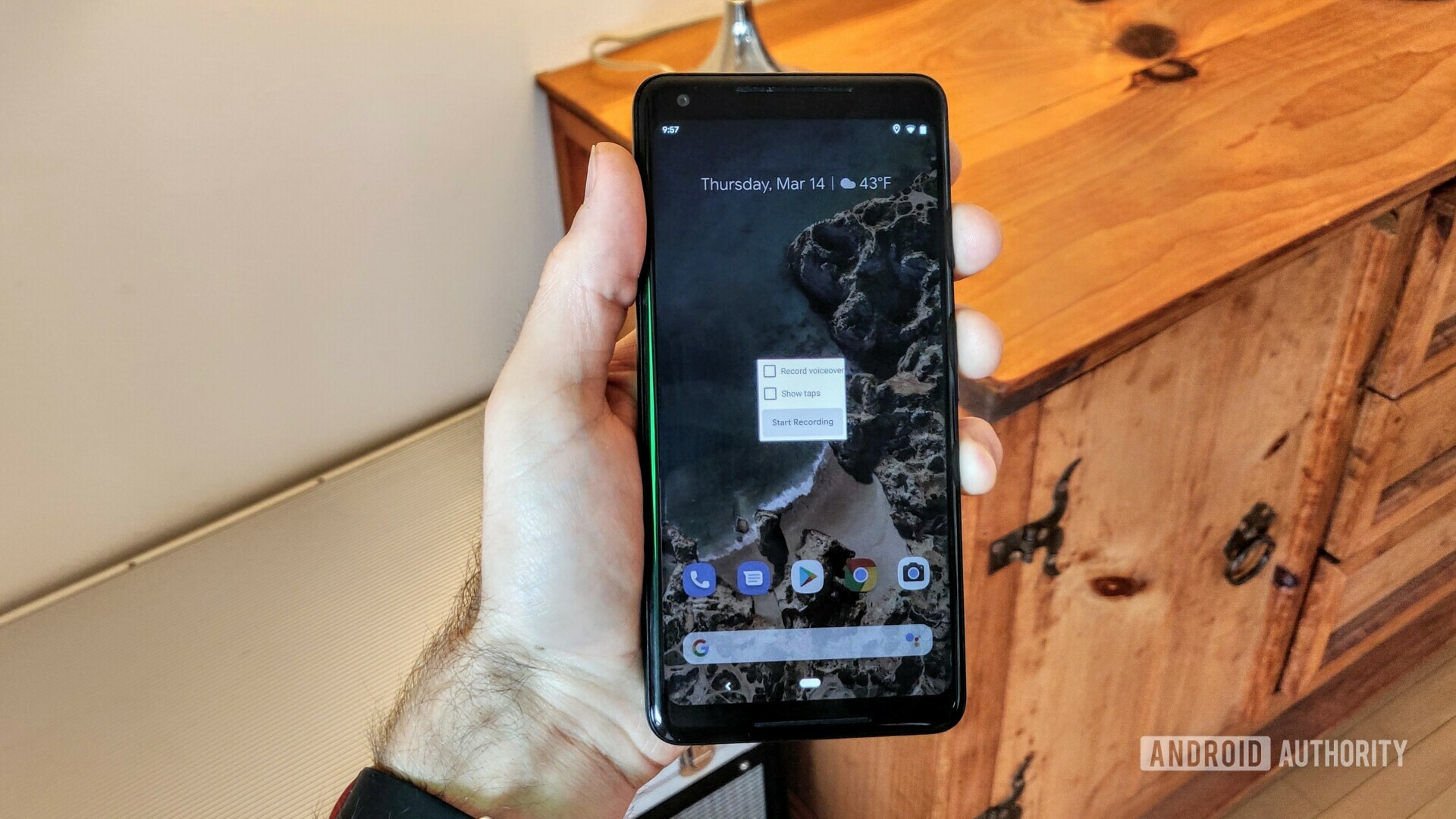 拿着一个谷歌像素2 xl的手的照片与显示的新的Android Q屏幕记录器。bob体育提现