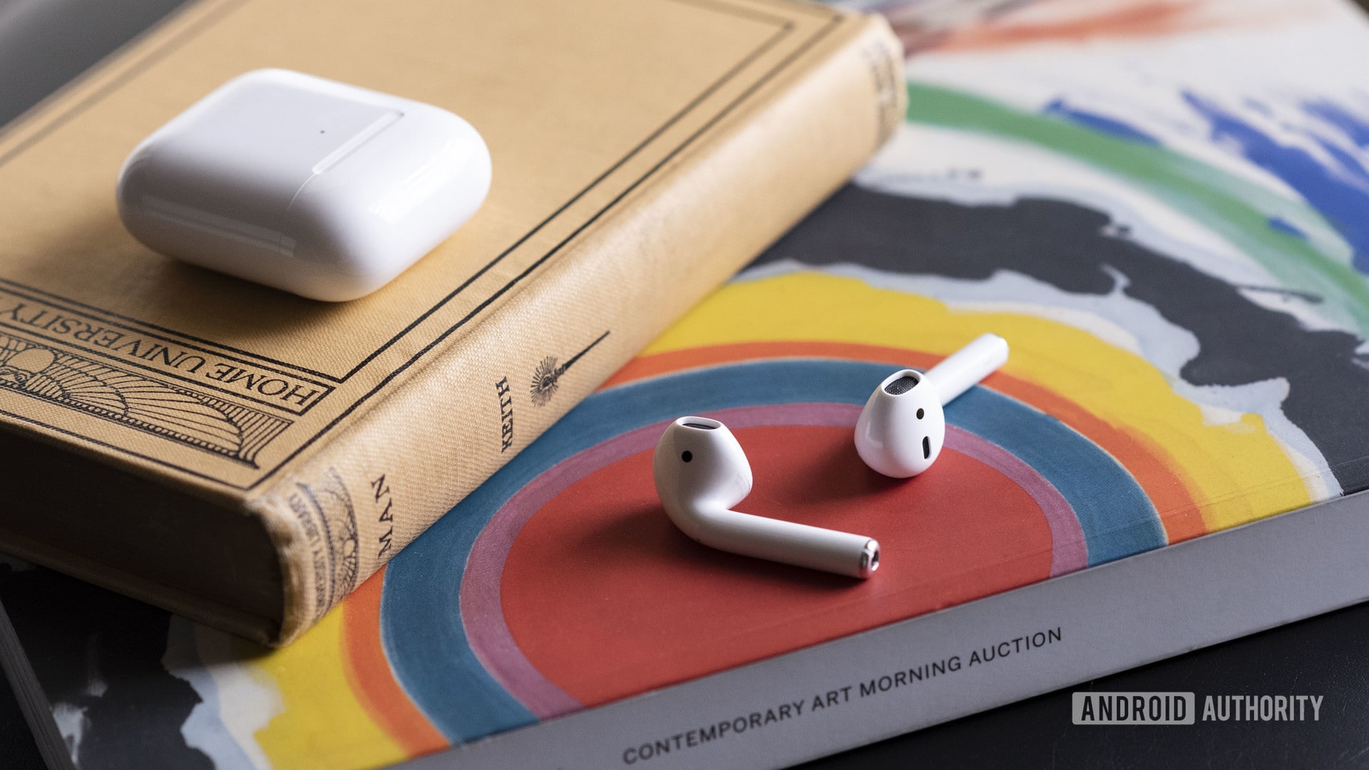 Apple New AirPods 2在案件外放在一本书上。