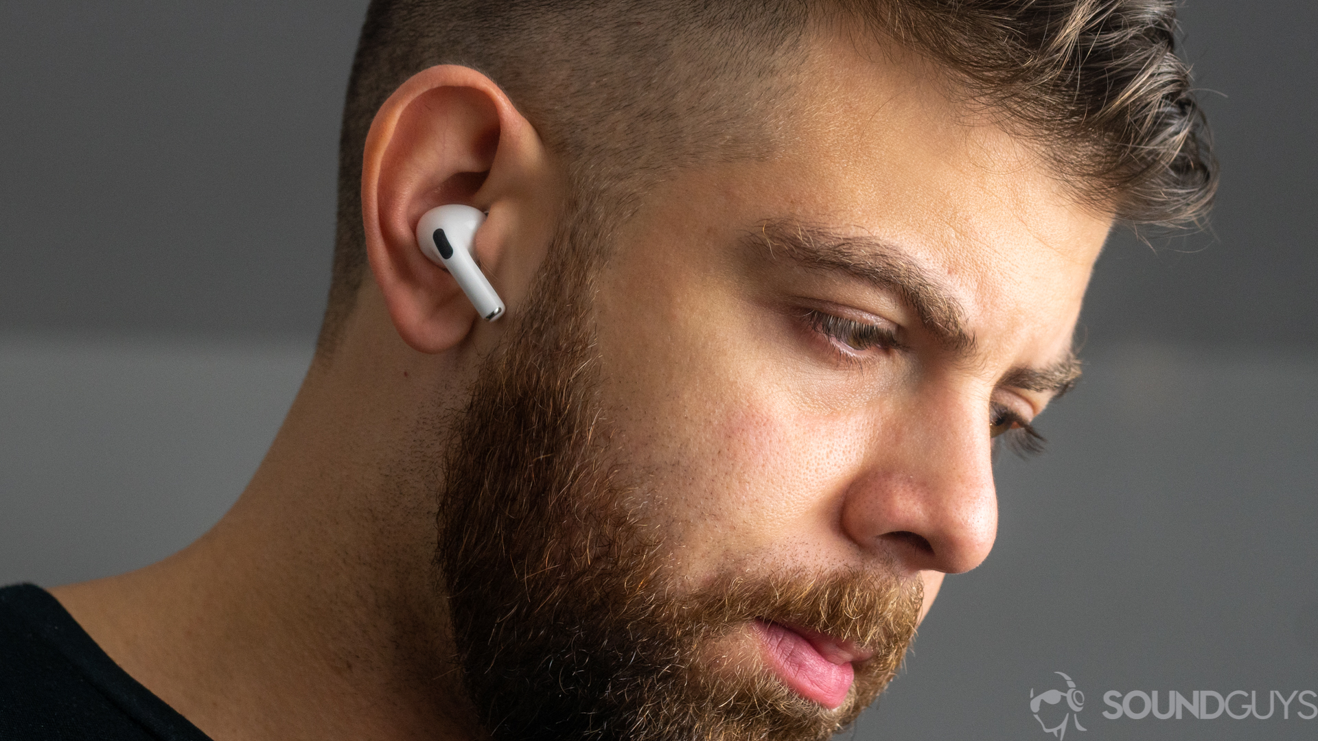 一张男子穿着Apple Airpods Pro噪声的真实无线耳塞的照片。