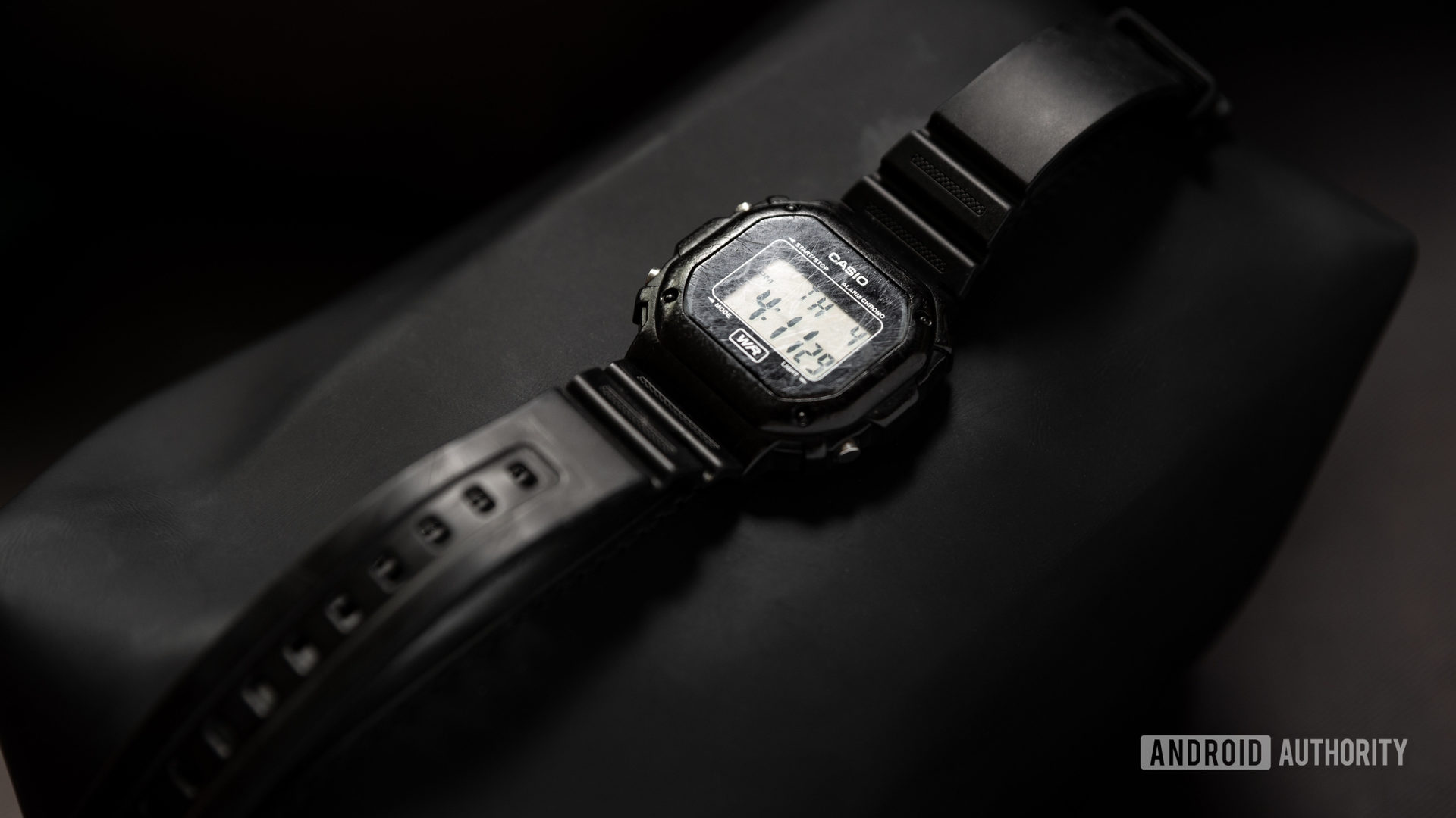 黑色Casio F108Wh照明器的图片在黑色表面上观看。