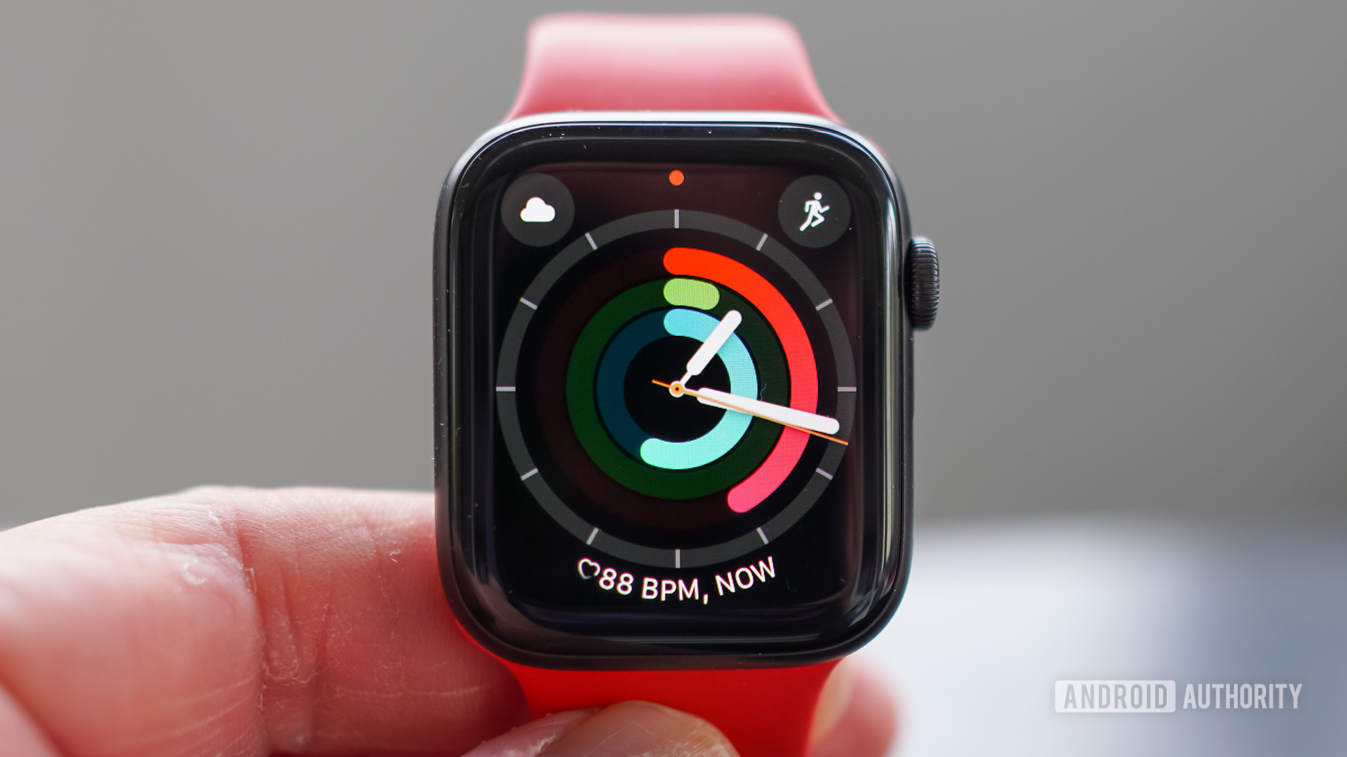 用户握住Apple Watch SE显示活动戒指手表面