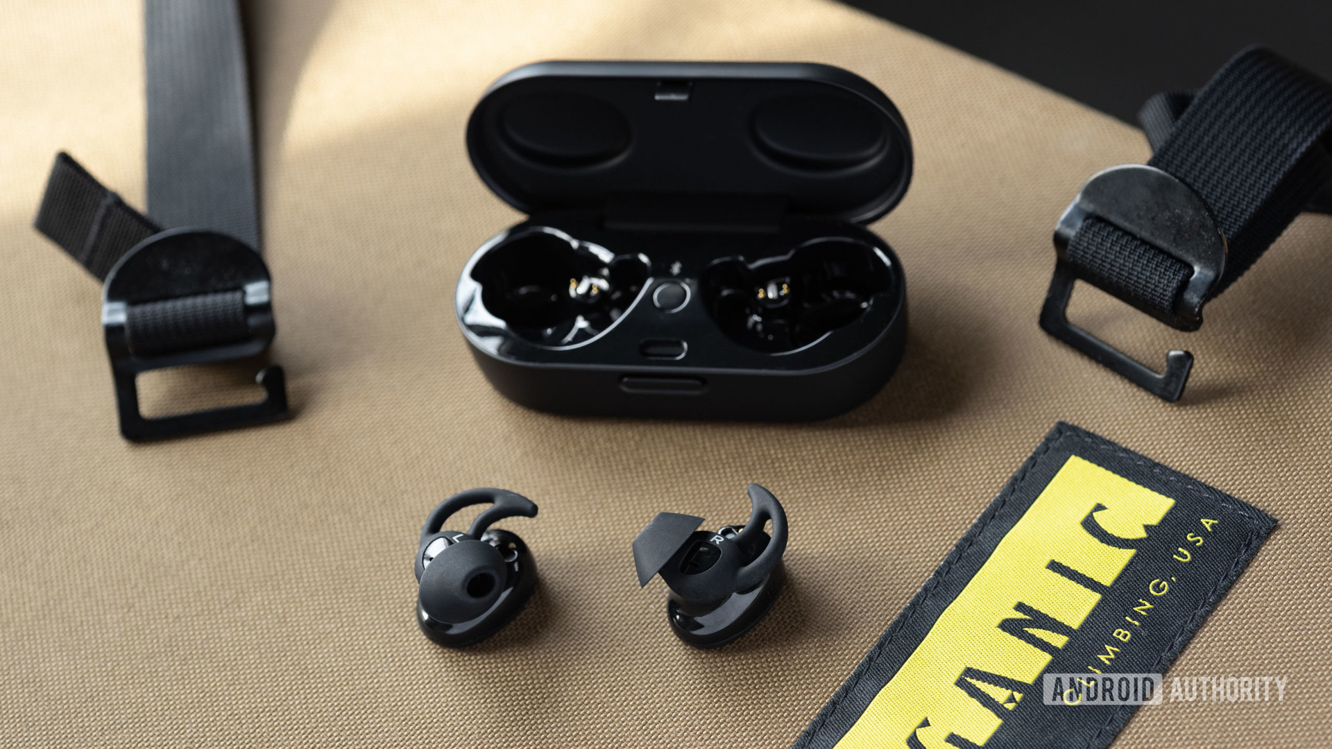 Bose Sport耳塞在开放充电箱外面的真实无线锻炼耳塞；耳塞正面向腹部，因此Stayhear Max Ear Tips处于全景状态。