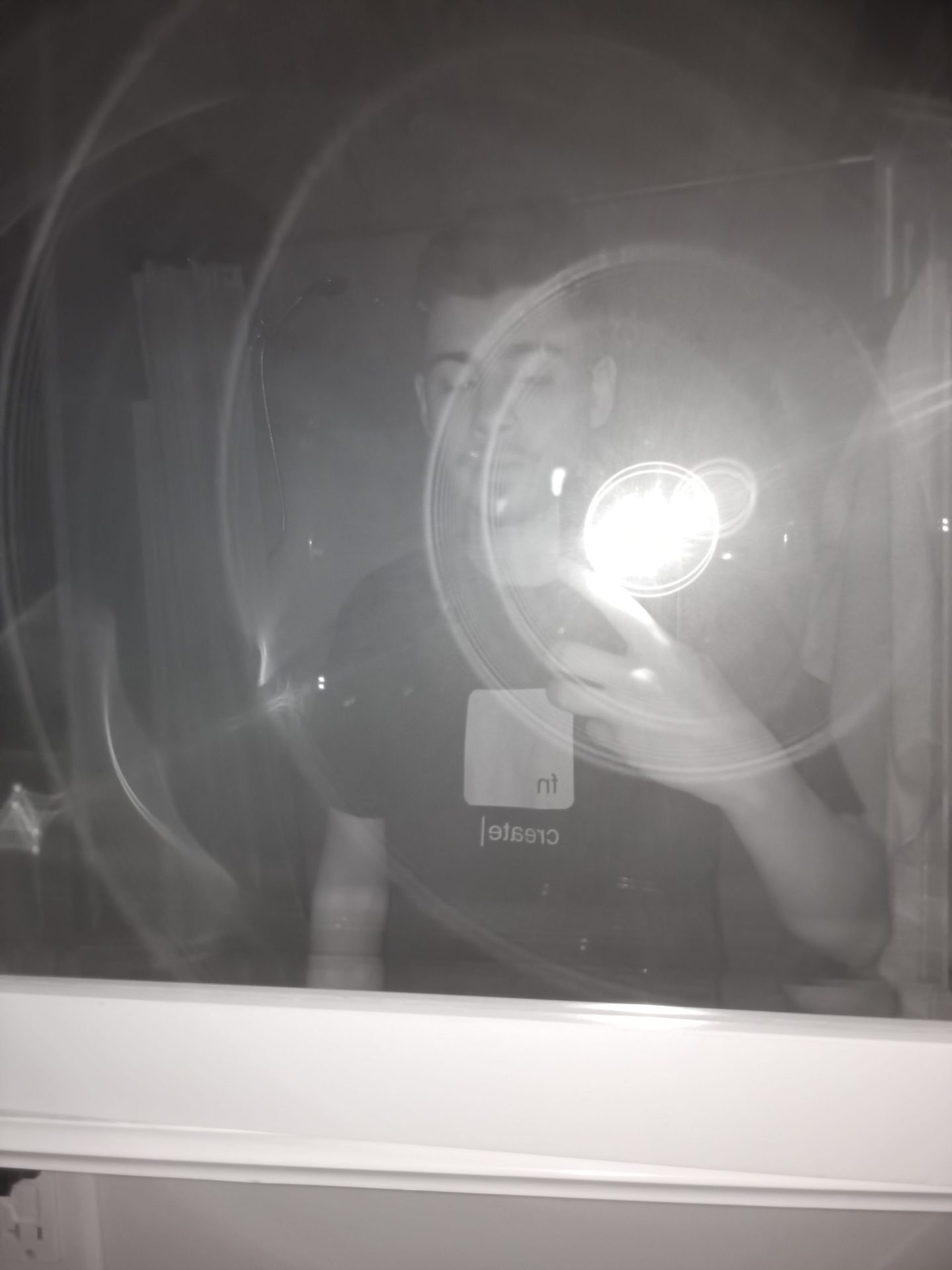 Ulefone Armor 11 5G夜视摄像机样本显示了一个穿着深色T恤的男人在镜子里拍照的照片，闪光灯反射。