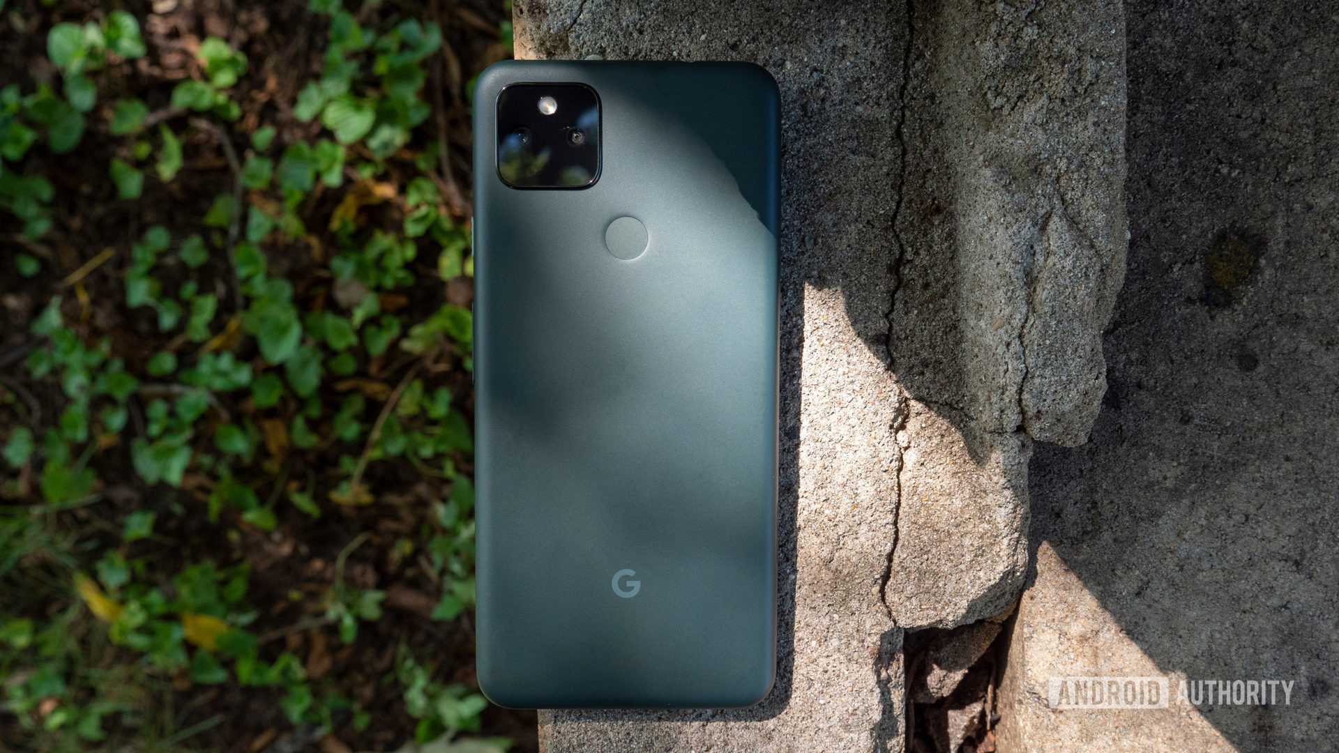 Google Pixel 5a在一块水泥上显示其背部大部分是黑色 - 带有夜间模式的电话