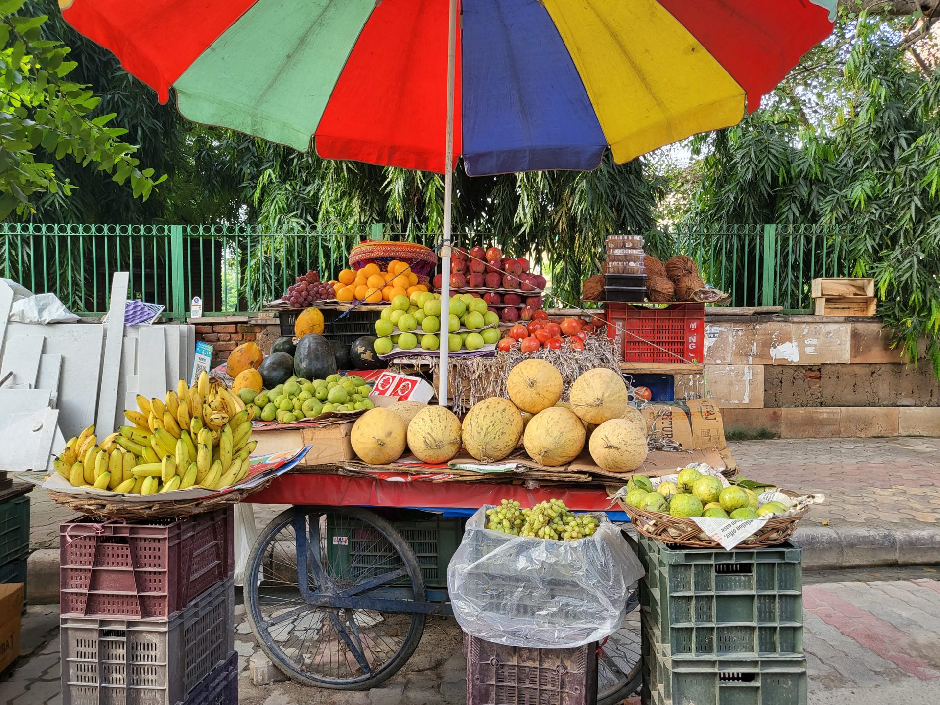 三星Galaxy Z翻转3初级摄像机果卖家站在水果和五颜六色的伞