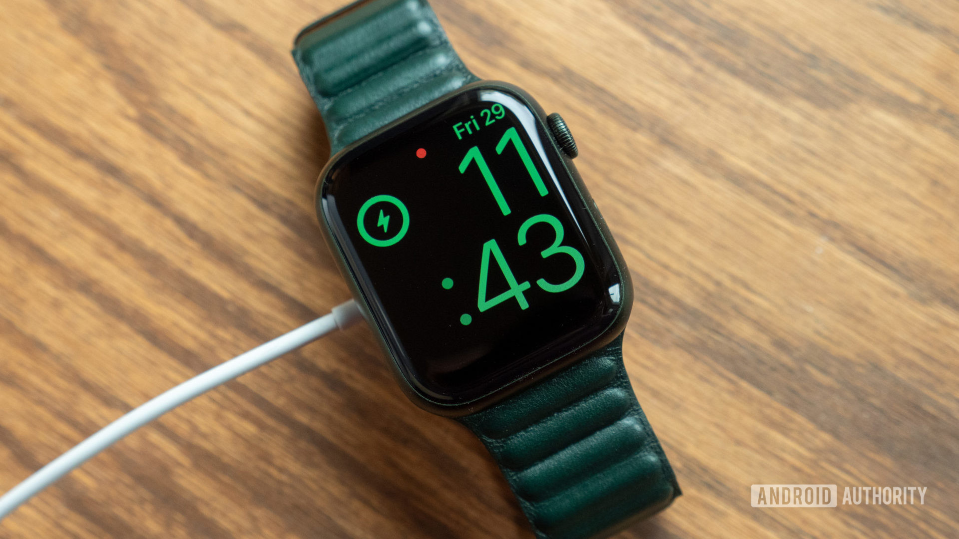 插入并充电的桌子上的Apple Watch系列7的图像