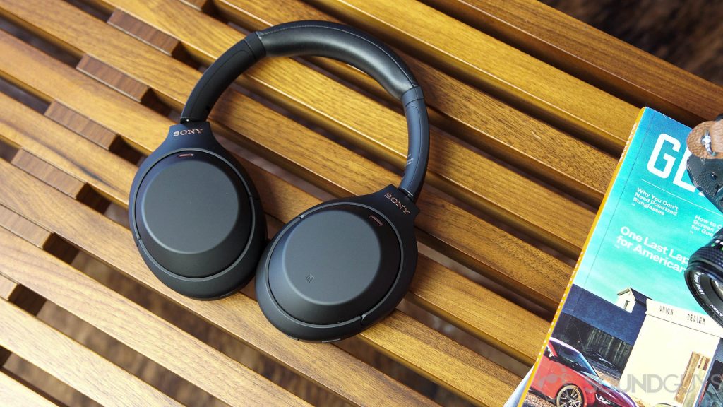 Sony WH-1000XM4耳机旁边的杂志旁边的木凳上