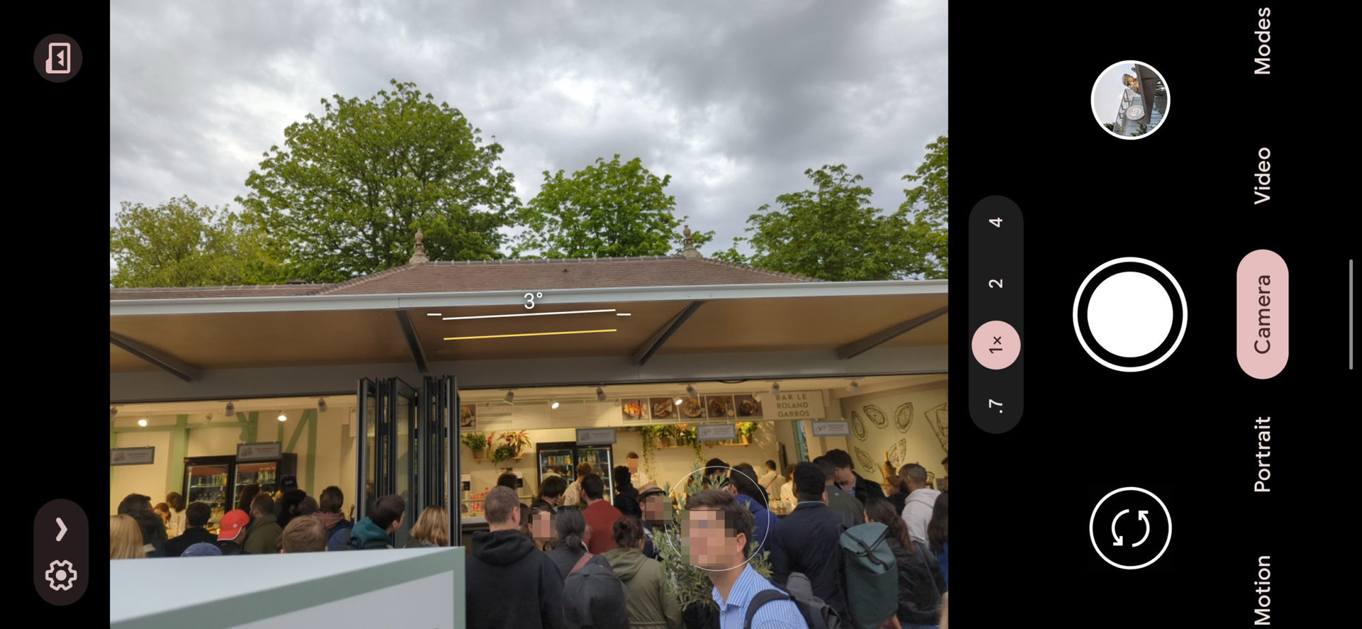 Google Pixel 6 Pro摄像头的屏幕截图在1X上显示一家食品商店，带有长队列
