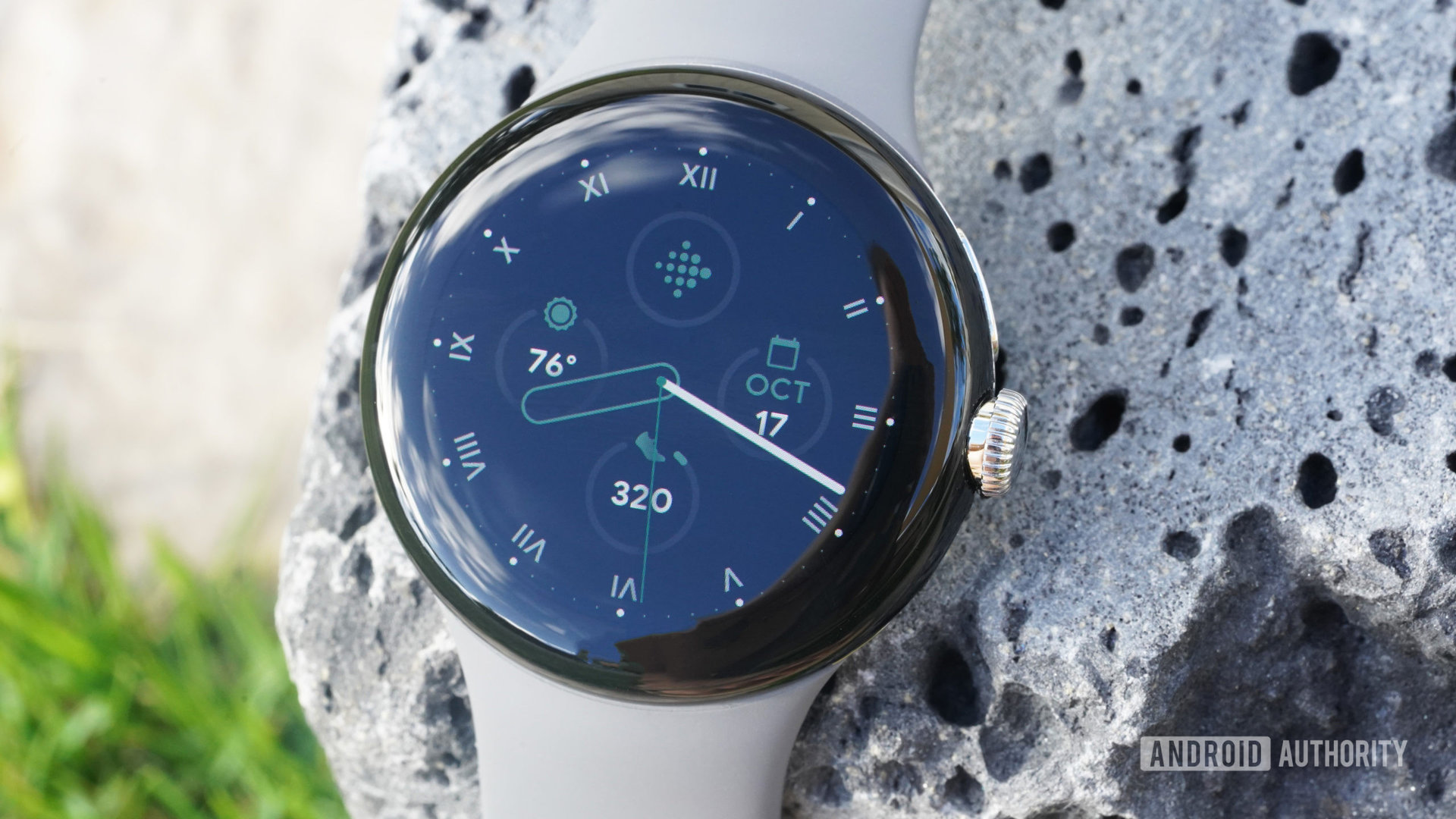 Google像素手表放在熔岩岩石上显示手表面。